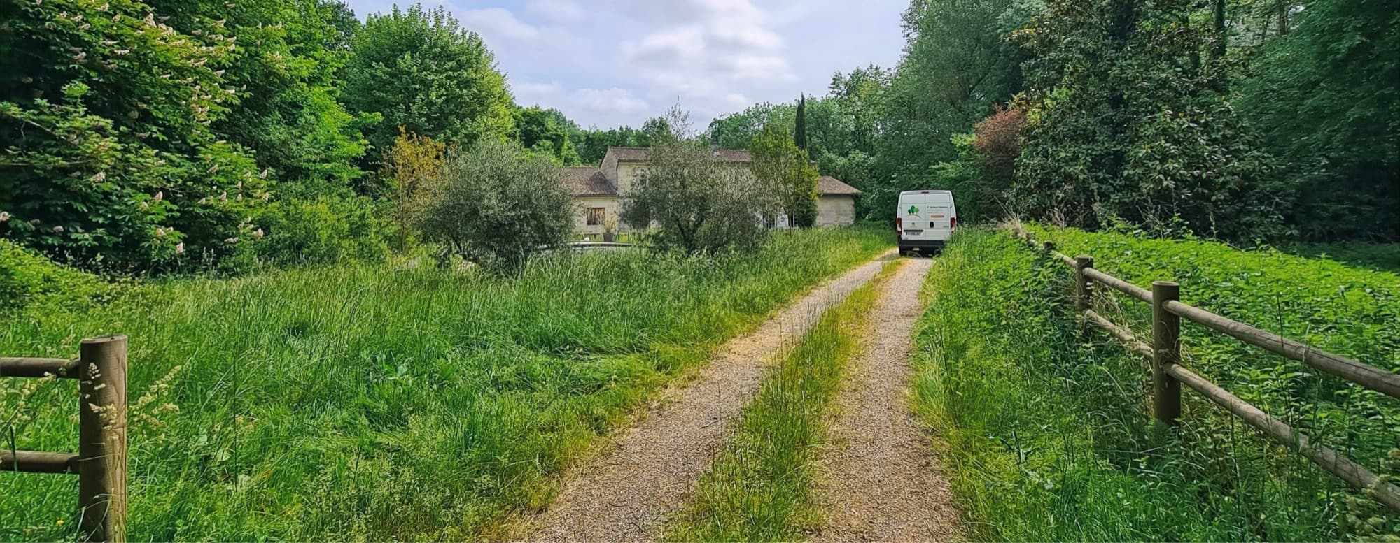 Le camion O’Jardins d’Aquitaine sur le chemin d’une propriété girondine, entre prairie fauchée et clôture bois